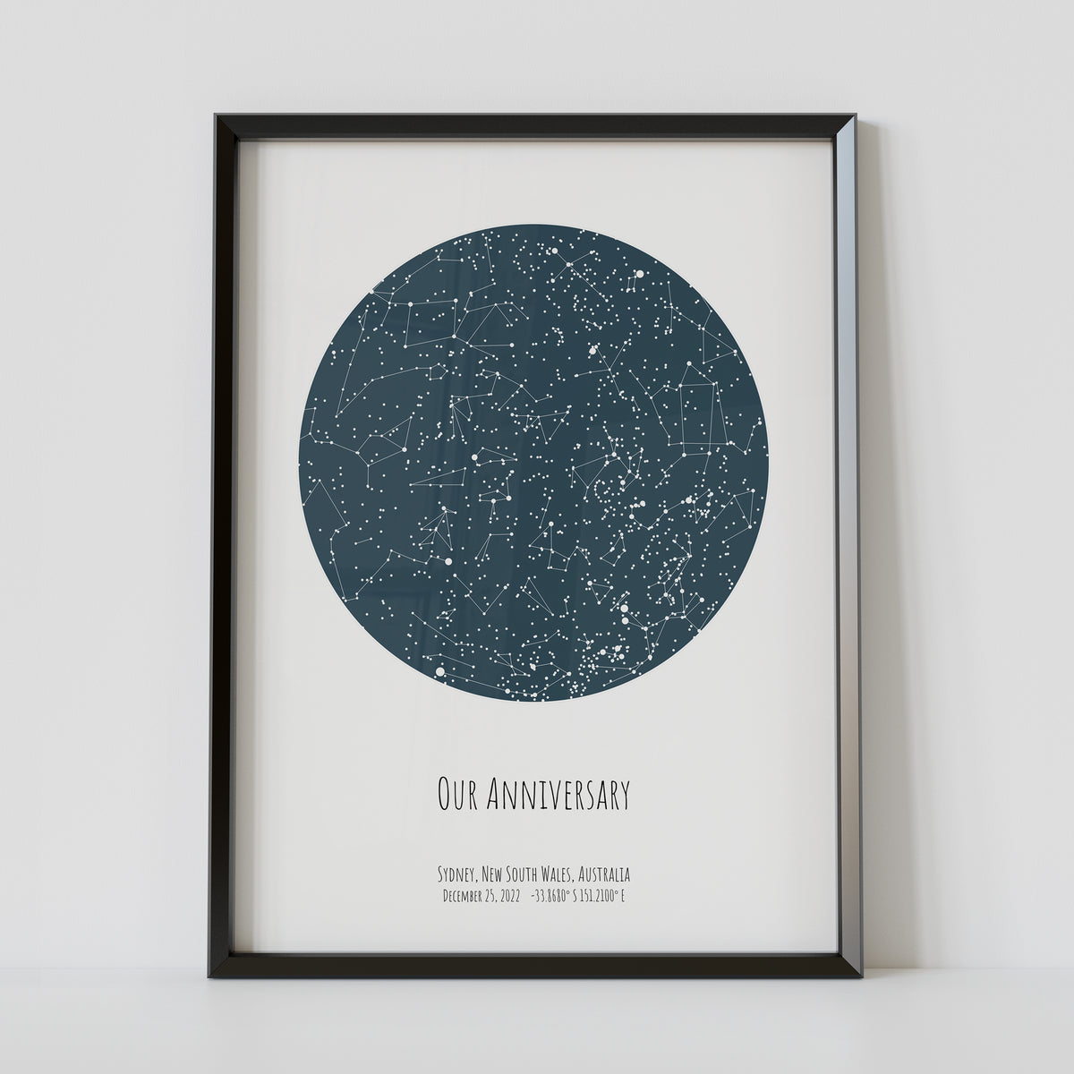 A framed blue constellation map poster, with a personalized quote "Our anniversary"